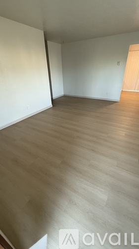 A room with wooden flooring and white walls.