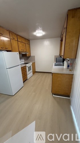 A kitchen with wooden cabinets and a white refrigerator.