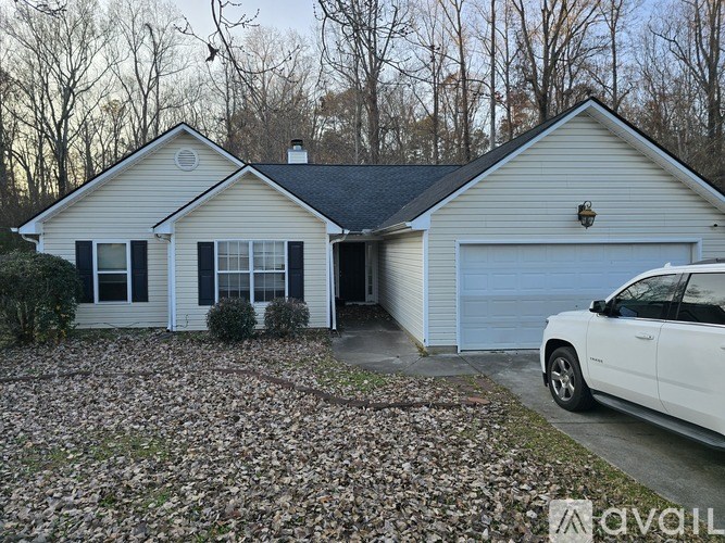 A house with a white car parked in front.
