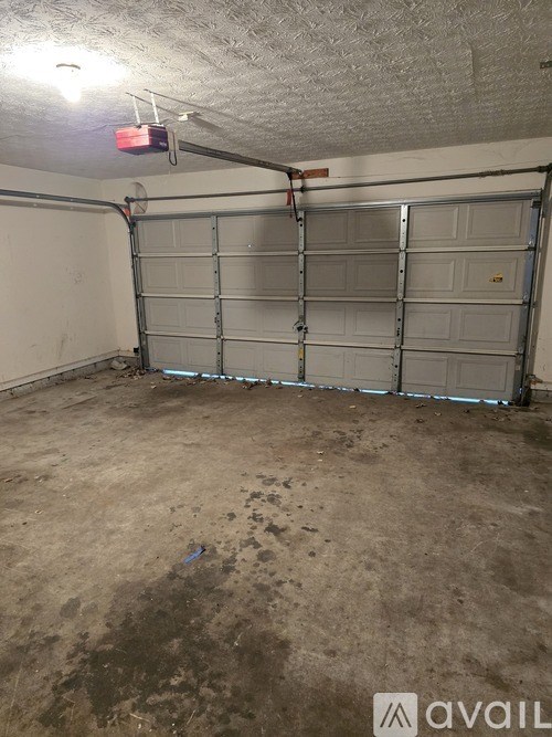 A garage with a closed door and a light on.