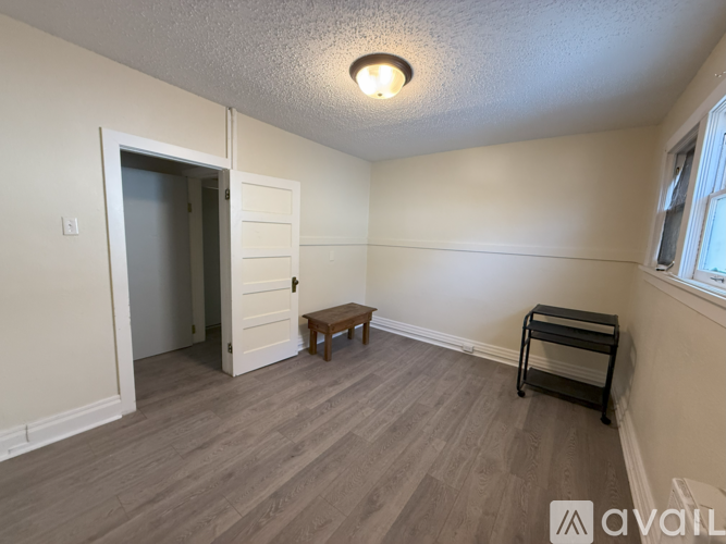 A room with a wooden floor and a bench in it.