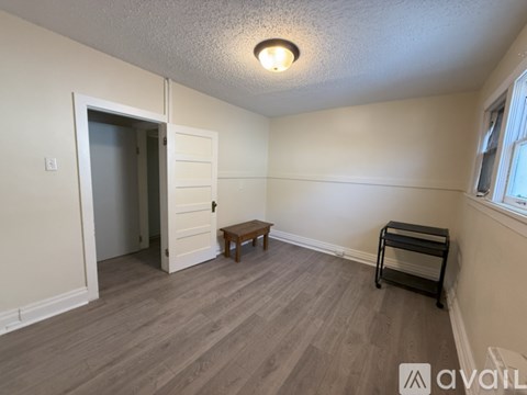 A room with a wooden floor and a bench in it.