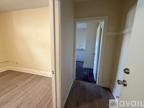 A room with a door and a wall with a small hole in it.