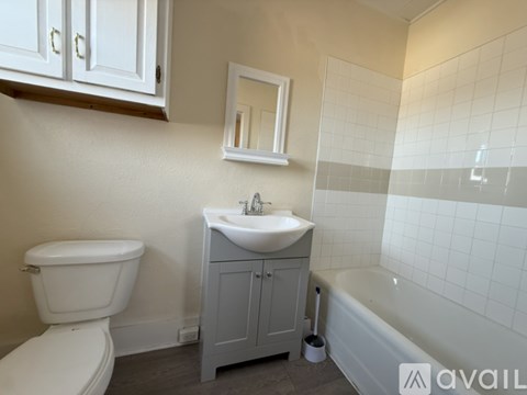 A bathroom with a toilet, sink, and bathtub.