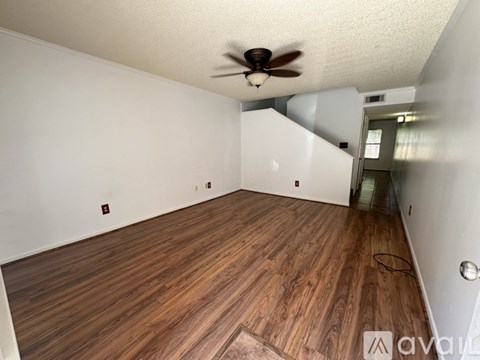 A room with wooden flooring and a ceiling fan.