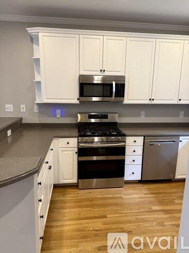 A kitchen with white cabinets and a stainless steel oven.