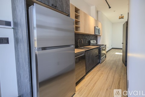 A modern kitchen with a stainless steel refrigerator and wooden cabinets.