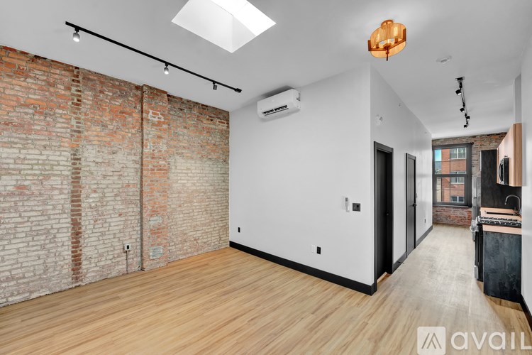 A room with a brick wall and wooden flooring.