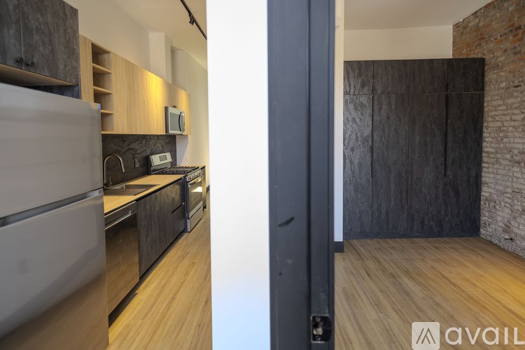 A modern kitchen with a refrigerator, oven, and microwave.