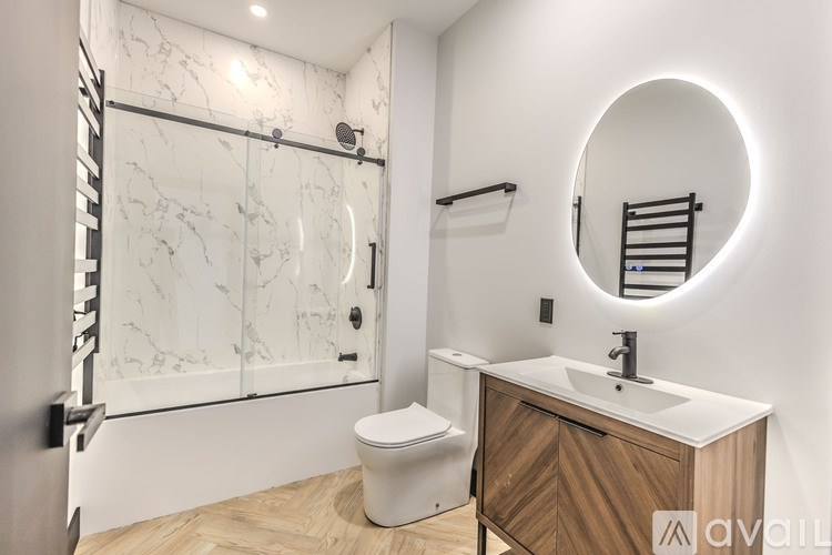 A bathroom with a marble wall and a round mirror.