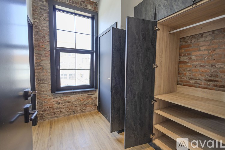 A kitchen with a black fridge and wooden floors.