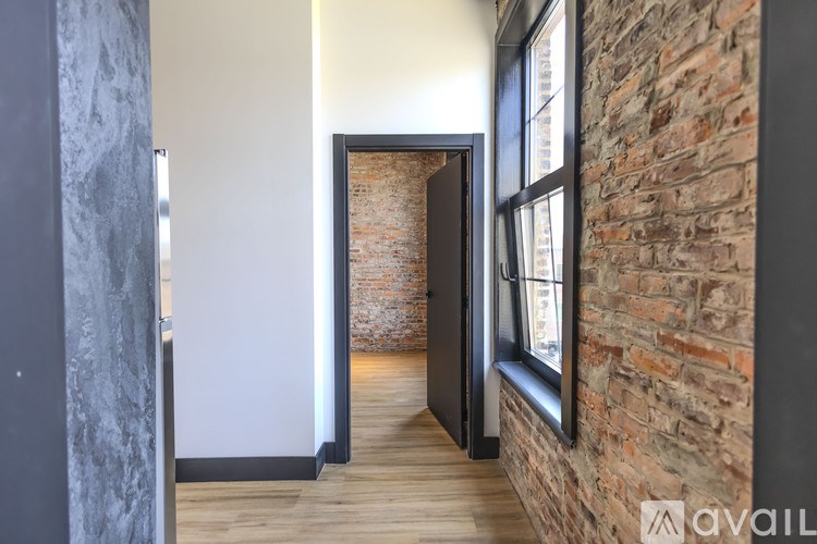 A hallway with a brick wall and a wooden floor.