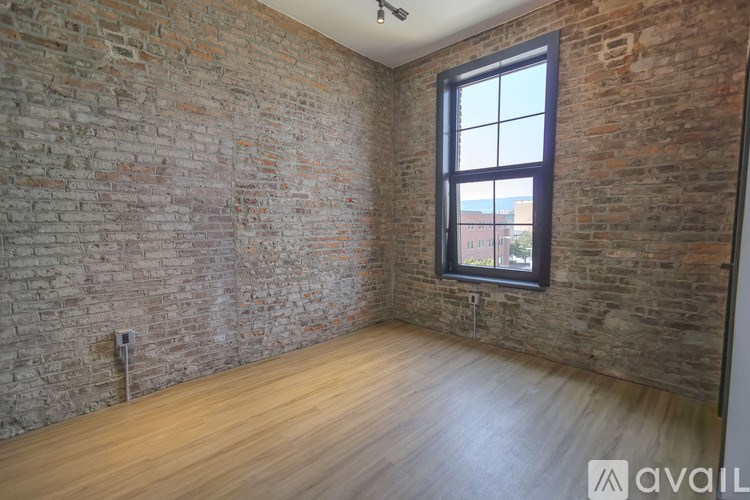 A room with a brick wall and wooden floor.
