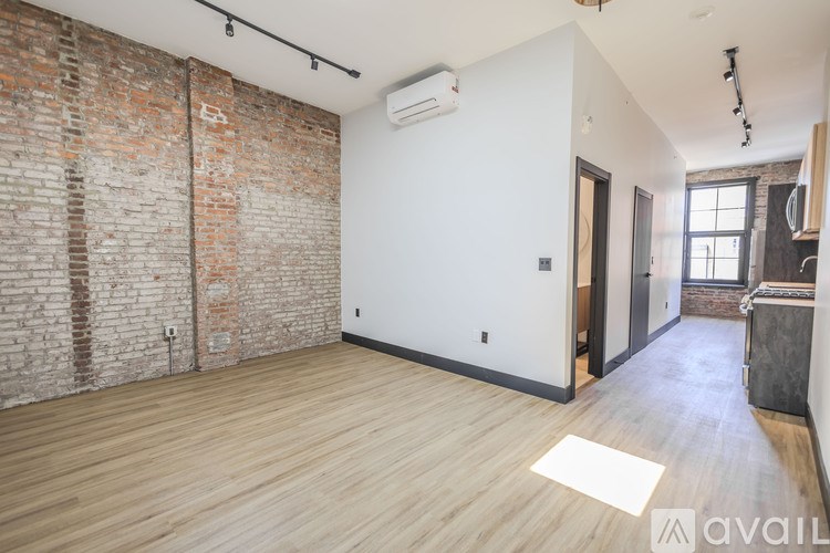 A room with a brick wall and wooden flooring.