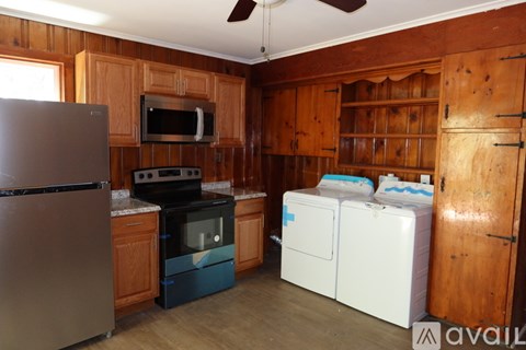 A kitchen with wooden cabinets and a refrigerator.