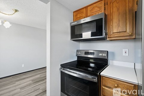 A kitchen with a black stove top oven and a black microwave above it.