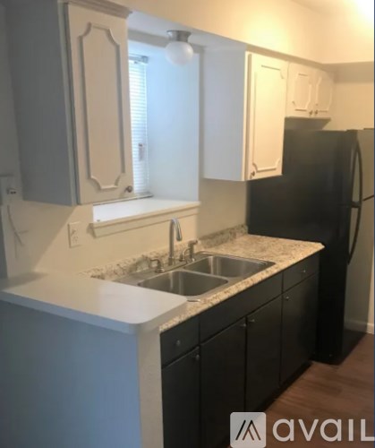 A kitchen with black cabinets and a black refrigerator.