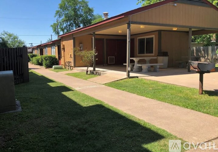 A sunny day at the outdoor seating area of a building with a red roof.