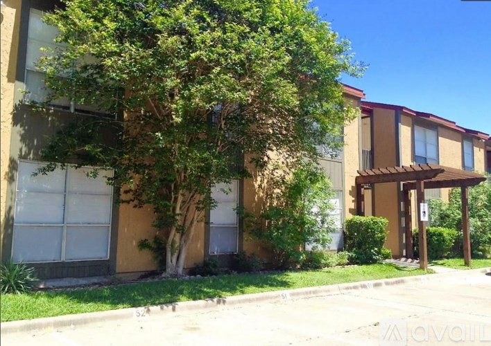 A tree in front of a building with a brown awning.
