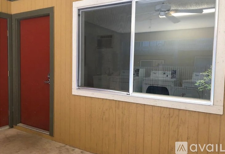 A red door is on the left and a window with a white frame is on the right.