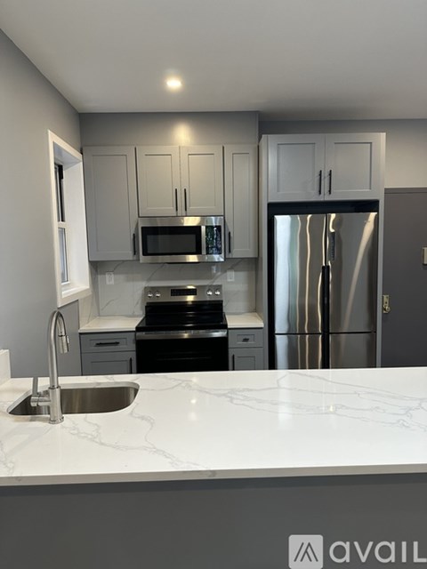 A kitchen with a sink, stove, and refrigerator.