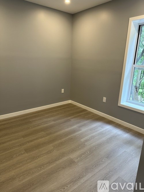 A room with wooden flooring and a window.