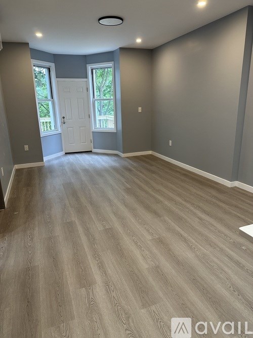 A room with wooden flooring and a white door.