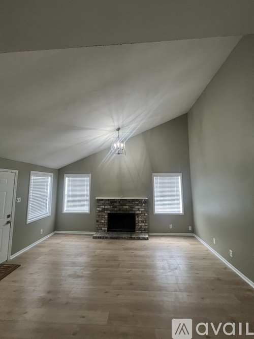 A spacious room with a fireplace and a large window.
