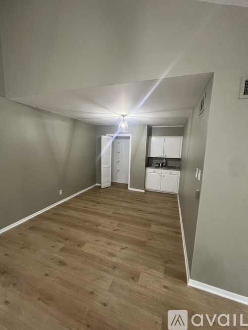 A room with wooden flooring and white walls.