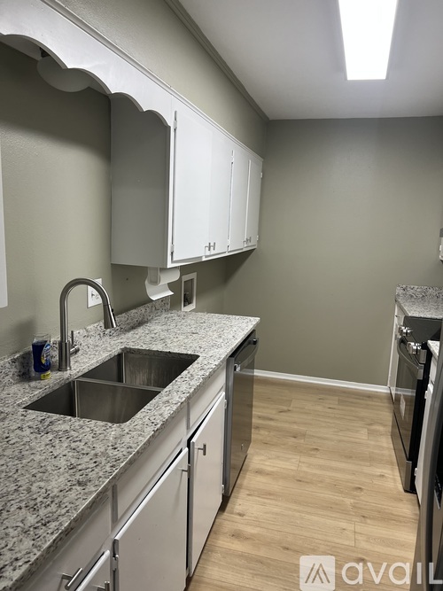 A kitchen with a granite countertop and stainless steel appliances.