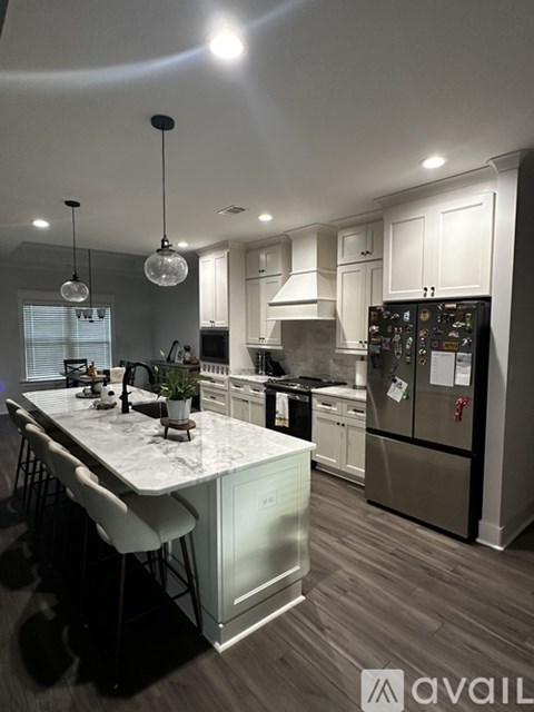 A kitchen with a marble island and stainless steel appliances.