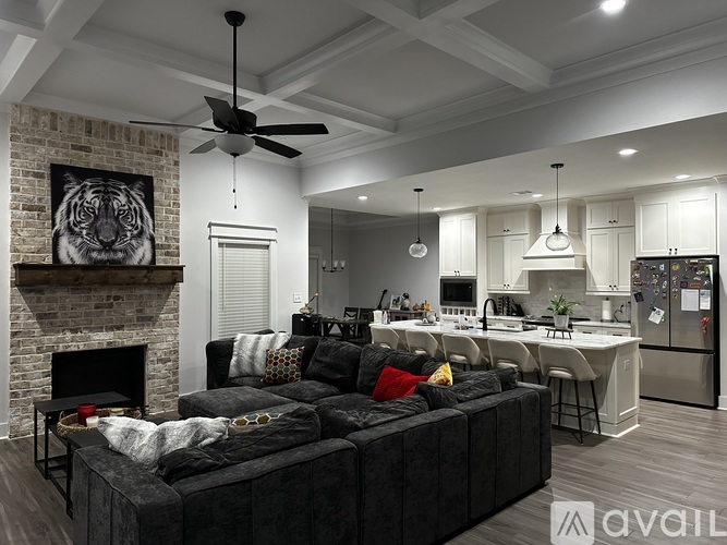 A modern living room with a black couch and a fireplace.