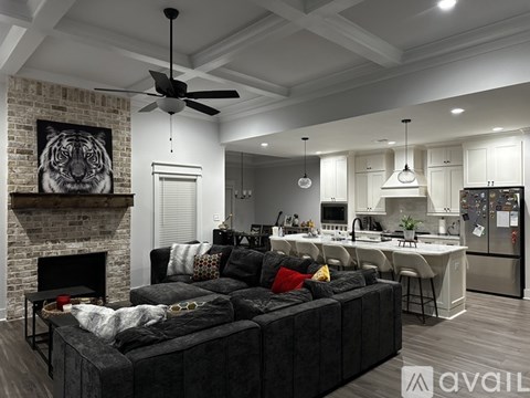 A modern living room with a black couch and a fireplace.