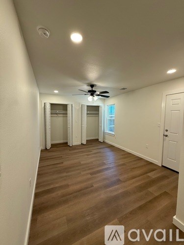 A room with wooden flooring and a ceiling fan.