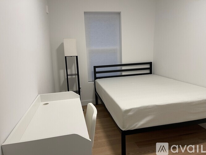 A small bedroom with a bed, desk, and chair.