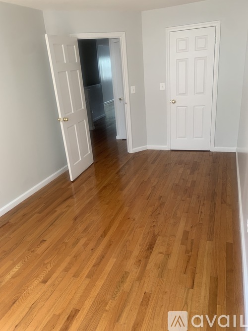 A room with wooden floors and two white doors.