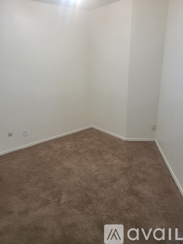 A room with a carpeted floor and a wall with a partially visible logo.