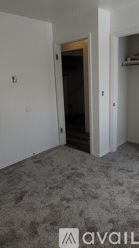A room with a carpeted floor and a door leading to another room.