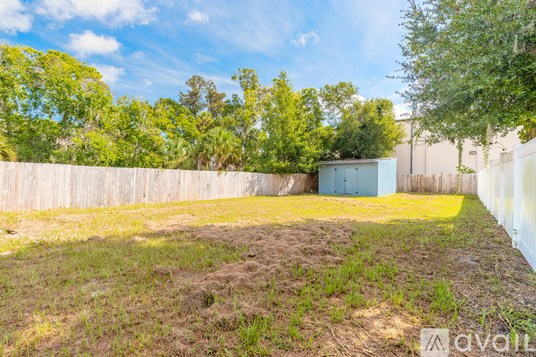 A backyard with a wooden fence and a green shed.
