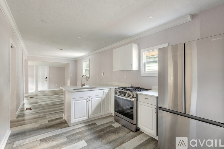A modern kitchen with white cabinets and stainless steel appliances.