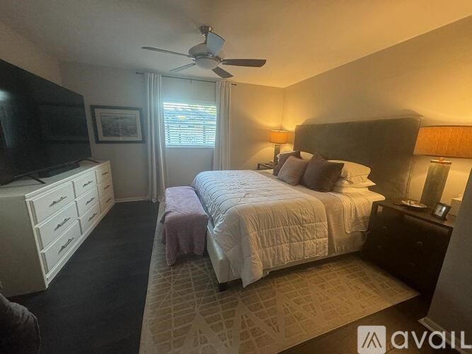 A bedroom with a bed, dresser, and television.