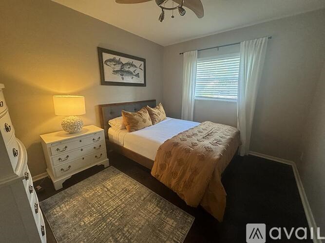 A bedroom with a bed, nightstand, and a ceiling fan.