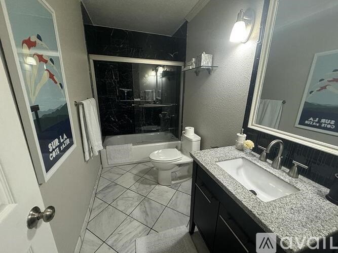 A bathroom with a white toilet, sink, and a mirror.