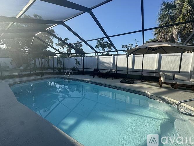 A pool with a glass ceiling and a sun umbrella.