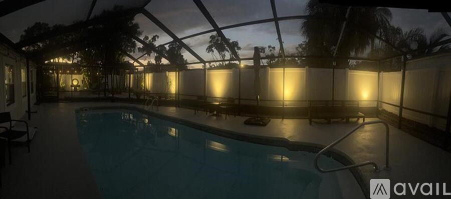 A swimming pool is lit up at night.