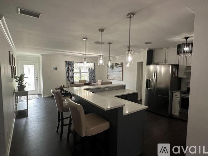 A modern kitchen with a large island and stainless steel appliances.