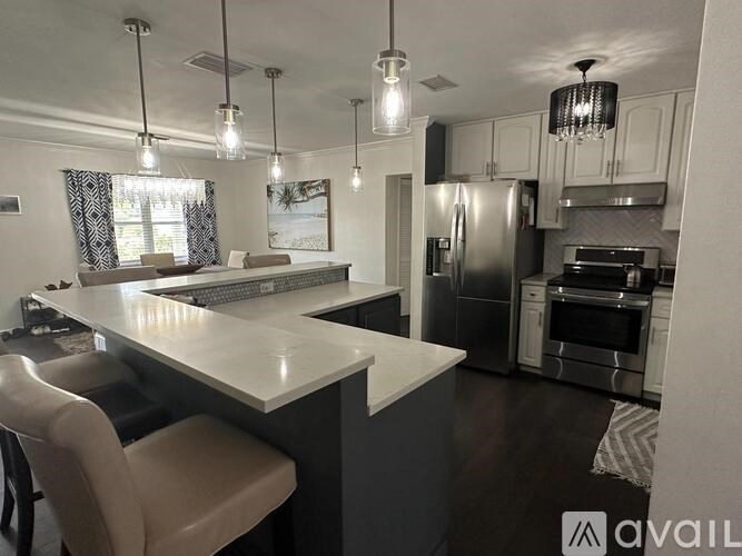 A modern kitchen with a large island and stainless steel appliances.