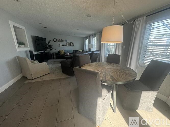 A living room with a grey couch, a round table, and a television.