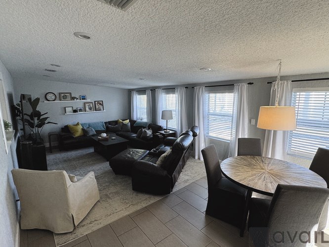 A living room with a couch, chairs, and a coffee table.