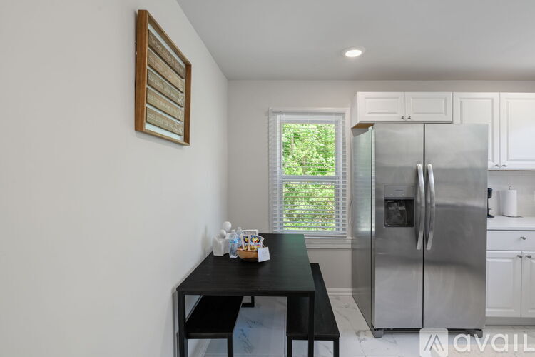 A kitchen with a black table and a refrigerator.